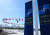 NATO flags flying under clear blue sky
