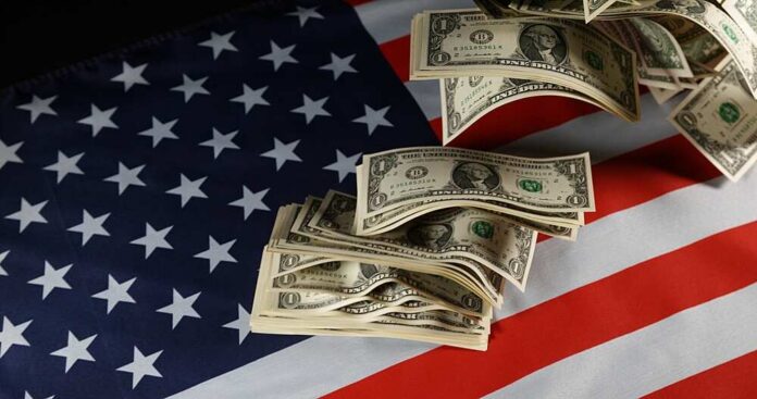 1,Us,Dollar,Banknotes,Flying,On,American,Flag Dollar bills arranged on an American flag