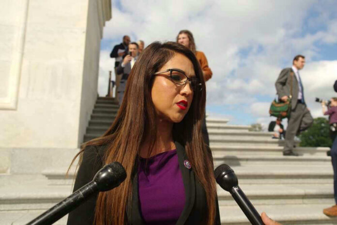 shutterstock_2370474763 Lauren Boebert speaking to reporters on stairs outside building