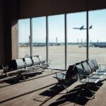 Heatwave Groundings Hit Major Hubs View of an airport waiting area with an airplane taking off in the background