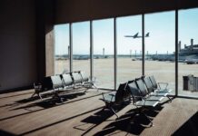 Heatwave Groundings Hit Major Hubs View of an airport waiting area with an airplane taking off in the background