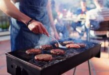 Big Bet on Grass-Fed Beef Person grilling burgers at an outdoor barbecue