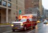 Lightning BLAST at Ohio Prison Ambulance with flashing lights driving on a wet city street