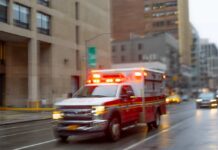 Lightning BLAST at Ohio Prison Ambulance with flashing lights driving on a wet city street