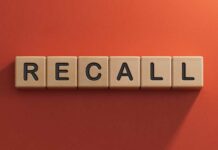 Danger Belts Trigger Massive Recall Wooden letter tiles spelling recall on an orange background