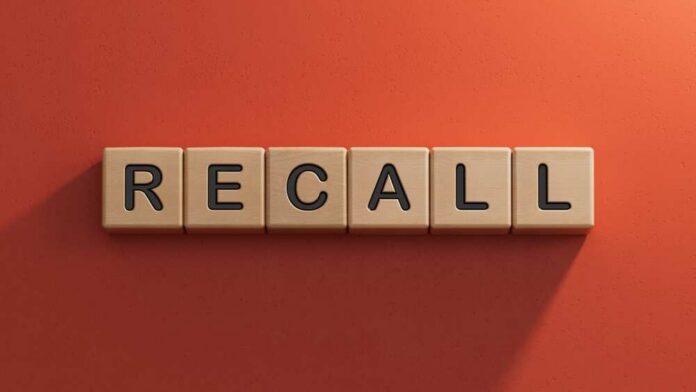 Wooden letter tiles spelling recall on an orange background