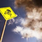 Grim Find – At Least 14 Dead Yellow skull and crossbones warning sign against smoky sky