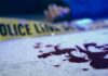 Horrific Double Murder Scene Stuns Nation Blood on pavement with police tape and a hand in the background
