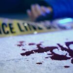 Horrific Double Murder Scene Stuns Nation Blood on pavement with police tape and a hand in the background