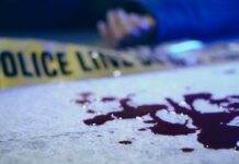 Horrific Double Murder Scene Stuns Nation Blood on pavement with police tape and a hand in the background