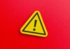 Yellow warning sign with exclamation mark on red background