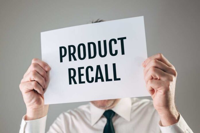 Businessman,Holding,A,White,Paper,Sign,With,Product,Recall,Text Person holding a sign reading product recall