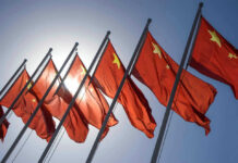 China-Backed Hackers Penetrate NASA, Fed, Senate Chinese flags waving under a clear sky.