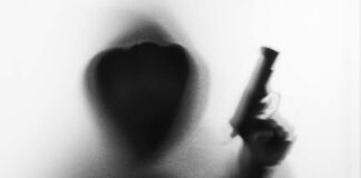 Silhouetted hooded figure holding a handgun