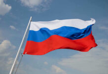 ALERT: Kremlin Hit Squad In D.C. Russian flag waving against a cloudy sky.