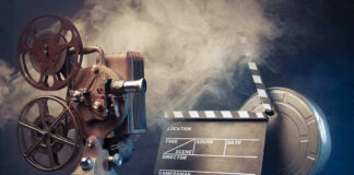 Vintage film projector and clapperboard with reels.