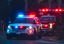 Mass Shooting at Block Party Police car and ambulance with flashing lights nighttime
