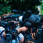 Burrito Gamble Flops — Betrayed by Numbers! TV news cameras crowding together at an outdoor event