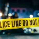 Masked Crew Hits THIS Sports Star’s Home Police line caution tape at a crime scene with blurred figures in the background