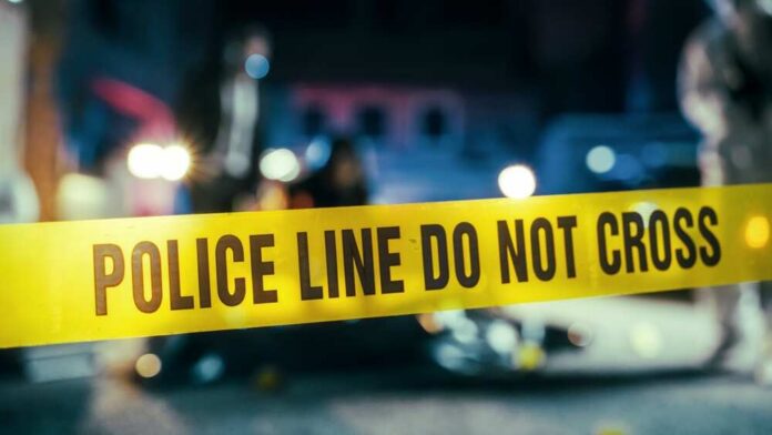 Yellow,Tape,Showing,Text,"police,Line,Do,Not,Cross",Restricting Police line caution tape at a crime scene with blurred figures in the background