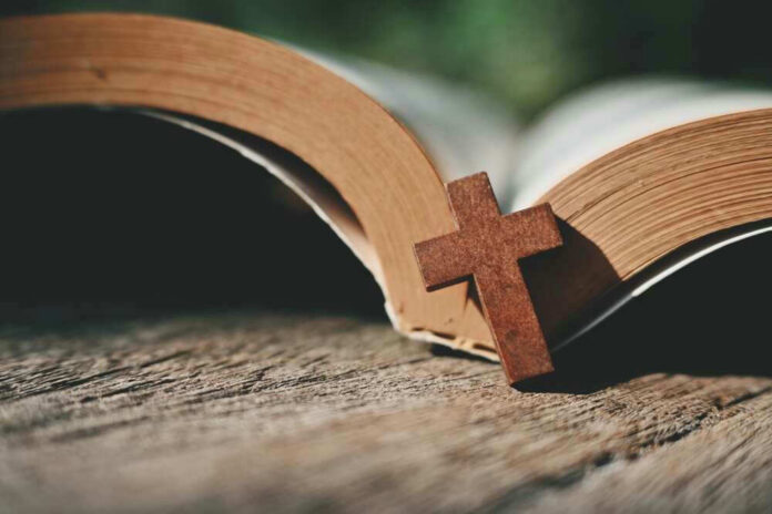 Open Bible with a wooden cross on it.