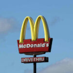 $8.5B Bet: McDonald’s Drops HUGE News McDonalds drive-thru sign against a blue sky.