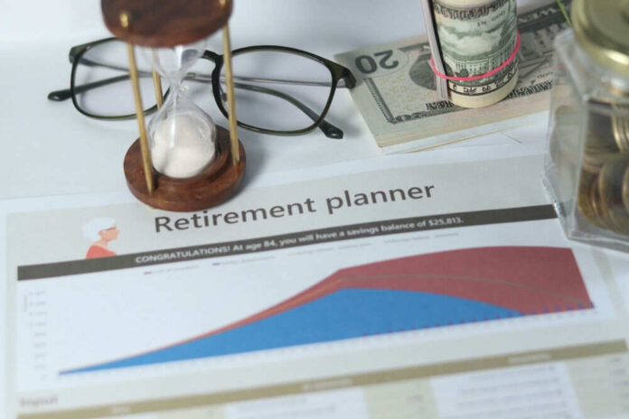 shutterstock_2485751417 Retirement planner graph with money glasses hourglass