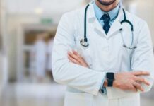 Universal Care Push Hits THIS Lib State A doctor in a white coat with a stethoscope standing with arms crossed