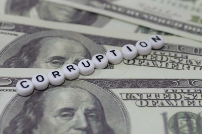 The,Word,"corruption",Spelled,Out,In,White,Beads,On,A US Capitol building with American flag and columns
