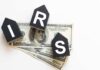 NOW: Surprise IRS Letters Promise Big Payouts Blocks spelling 'IRS' placed on top of hundred dollar bills featuring Benjamin Franklin