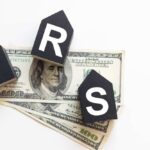 NOW: Surprise IRS Letters Promise Big Payouts Blocks spelling 'IRS' placed on top of hundred dollar bills featuring Benjamin Franklin