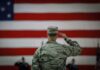 VIDEO: U.S. Strikes Back – New Military Action A military personnel saluting in front of a large American flag