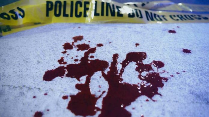 Close-up,Of,Blood,Stains,On,Crosswalk,Asphalt,Near,Yellow,Police Blood stains on a surface with police caution tape in the background