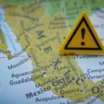Safety Alert: Vehicle Software Glitch Risk Exposed! A close-up of a map of Mexico with a yellow warning sign placed on it