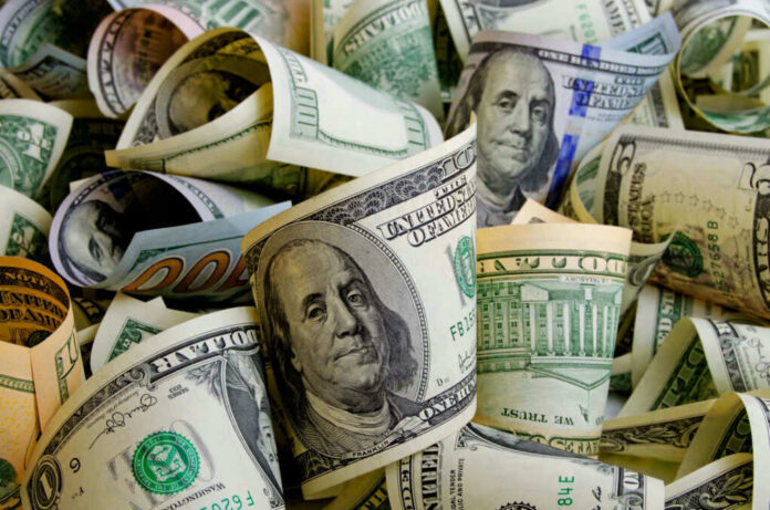 shutterstock_518001346 Rolled U.S. dollar bills in various denominations.