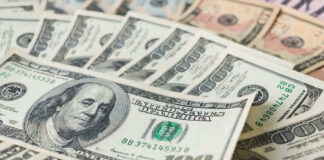 Stacks of various U.S. dollar bills.