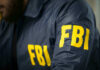 These FBI Files Exposed! Blackmail Fears Surge FBI agent in navy blue jacket.