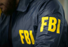 These FBI Files Exposed! Blackmail Fears Surge FBI agent in navy blue jacket.