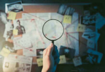 Lagoon Clue Revives Aviation Mystery Magnifying glass over investigation board with photos and strings.