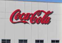 Coca-Cola Drops Flavor Bombshell Red script logo on a white building facade