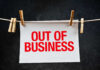 Huge Chain COLLAPSES – 76 Stores Axed paper sign with red lettering clipped to a clothesline