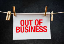Huge Chain COLLAPSES – 76 Stores Axed paper sign with red lettering clipped to a clothesline