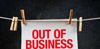 paper sign with red lettering clipped to a clothesline