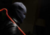 Million-Dollar Heist Hits PSA Person in mask holding crowbar in dimly lit room.