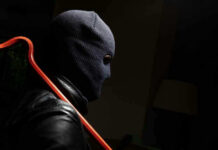 Million-Dollar Heist Hits PSA Person in mask holding crowbar in dimly lit room.
