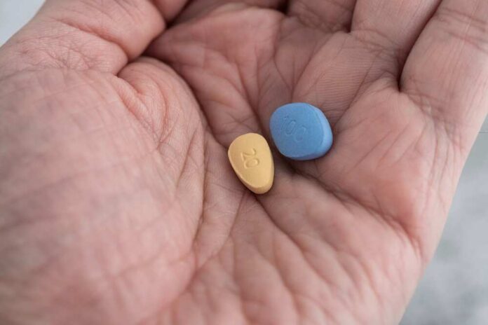 Two,Blue,And,Brown,Pills,In,Male,Hand.,Medicine,Concept