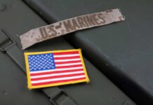 Marine Arrest Sparks Lockdown Military patches including a US Marines insignia and an American flag on a green surface