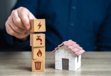 Nationwide Squeeze: Water Costs Spike Person stacking utility icon blocks beside a small model house