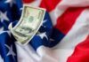 A hundred dollar bill resting on an American flag