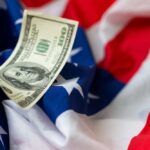 Billion-Dollar Pledge Stuns Parents A hundred dollar bill resting on an American flag